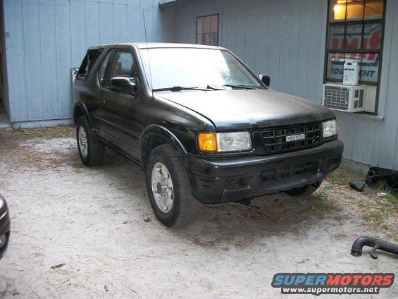 Black 1993 Isuzu Rodeo parked on dirt lot, front 3/4 view