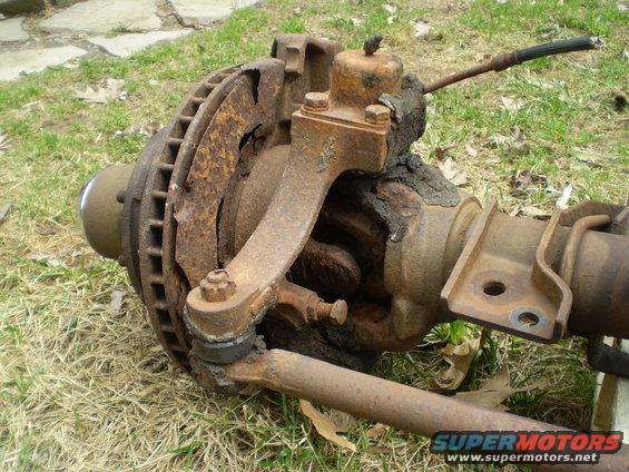Rusted front axle assembly with brake rotor and suspension components