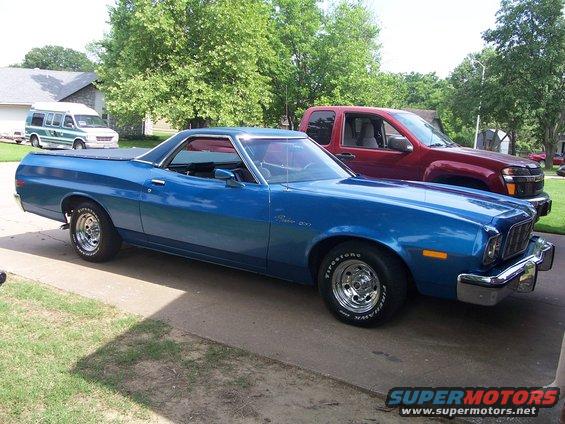 Blue 1973 Ford Ranchero with a red truck behind it