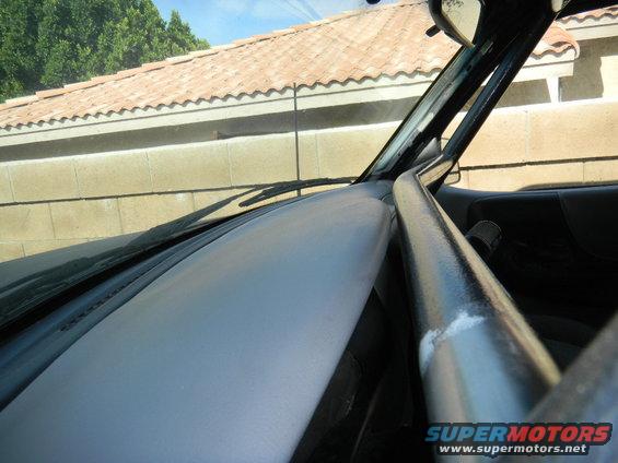 Interior view of a vehicle showing a roll cage bar and dashboard with a Supermotors.net watermark