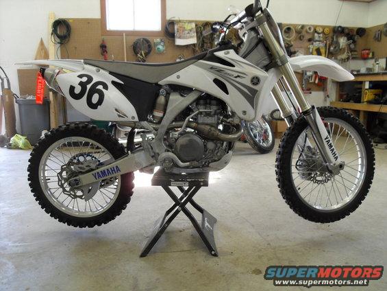 2007 Yamaha YZ450F dirt bike on a stand in a garage, number 36 on the rear fender