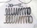 1973 Ford Ranchero - A spring compressor tool sits above two sets of used coil springs, one set appearing darker than the other.