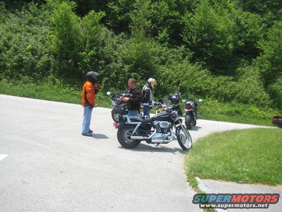 Motorcycle on a winding road with a person standing nearby