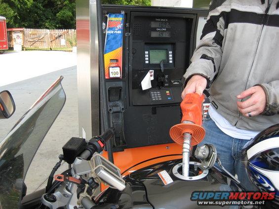 Motorcycle refueling at gas station pump