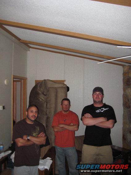 Three men with arms crossed indoors
