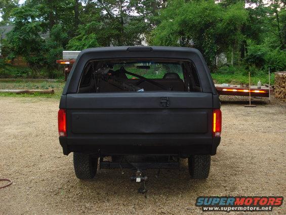 Black SUV rear view, matte finish, trailer hitch, aftermarket taillights
