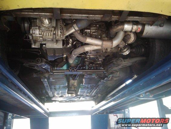 Underbody view of a car with a supercharger and custom exhaust system