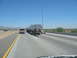 1993 Ford Taurus - A truck transports a large cylindrical object on a highway under a clear blue sky.
