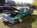 1973 Ford Ranchero - A green 1973 Ford Ranchero is parked with its hood up, revealing the engine bay.