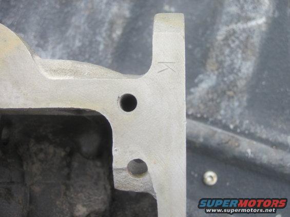 Engine part with K marking and bolt holes