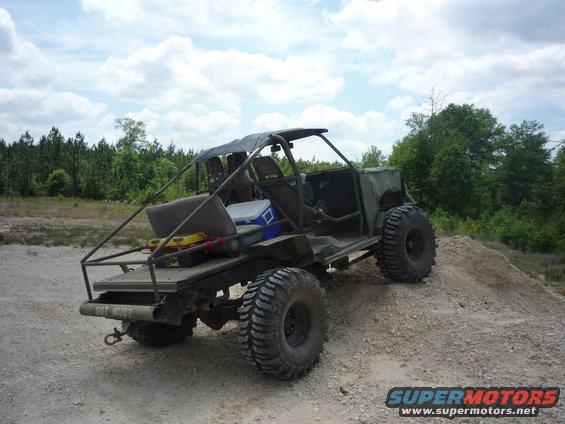 Custom off-road vehicle with large tires and open-air design, rear view