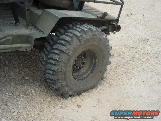 Off-road vehicle's large, aggressive tire and rear fender assembly on a dirt surface