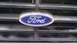 1984 Ford Bronco - The blue Ford oval emblem is centered on the horizontal bars of the vehicle's grille.