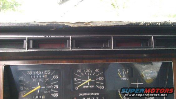 1984 Ford Bronco dashboard with wood grain trim, speedometer, tachometer, fuel, and oil gauges