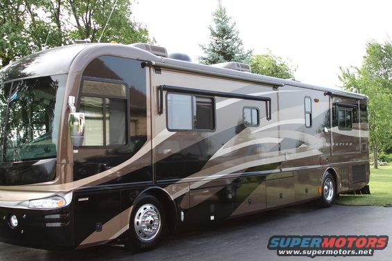 Brown motorhome with beige and black wavy stripes, side view