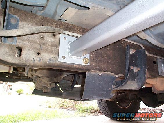 dcp00467.jpg Passenger side slider mounted and held in place with one bolt. Undo the clips that hold the fuel return line and move them up and out of the way. The best way to hold the slider in place is with a floor jack and a couple of two by four so you can jack the slider up flush with floor of the truck. Our jack was broken so we had to improvise.