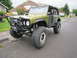 1974 Ford Bronco - This modified 1974 Ford Bronco features oversized tires, a custom bumper, and a roll cage, indicating significant off-road capability.