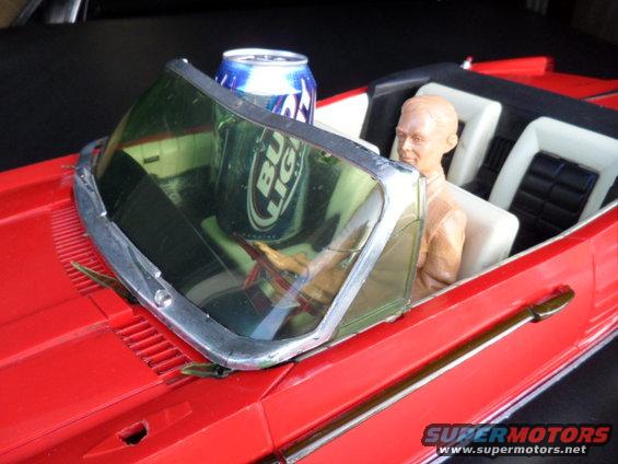 Red model car interior with Bud Light can and doll driver