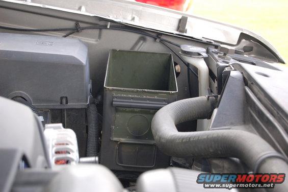 Engine bay with ammo can toolbox installed next to radiator hose