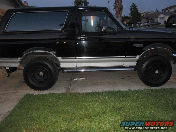 Side view of black 1992 Ford Bronco with silver trim and chrome steps