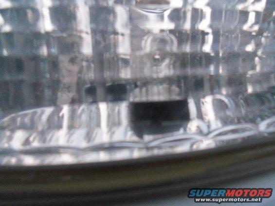Headlight assembly with clear textured lens and internal bulb housing