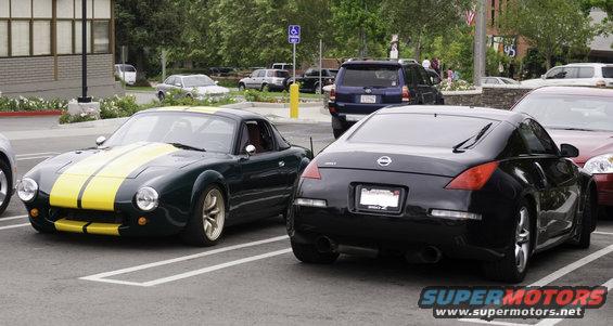 Dark green car with yellow stripes parked next to a black Nissan 350Z