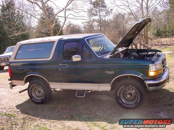 1992 Ford Bronco parked outside with hood open, another vehicle visible in background