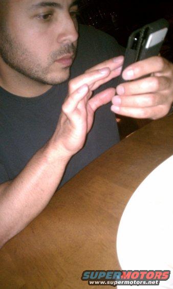 Guy looking at his phone at a table