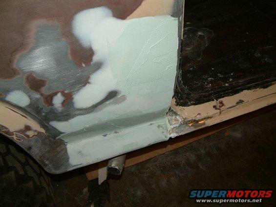 car body panel being repaired with body filler and primer