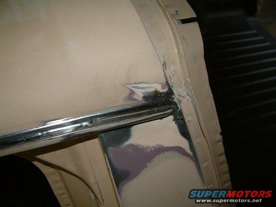 Close-up of vehicle body panel with primer and metal work visible