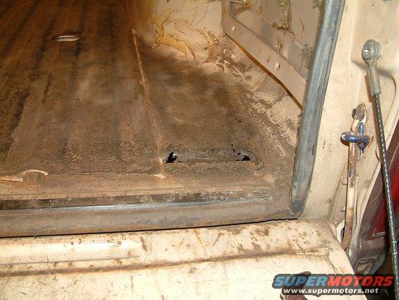 Rear cargo area interior with rust and holes. Supermotors.net watermark visible