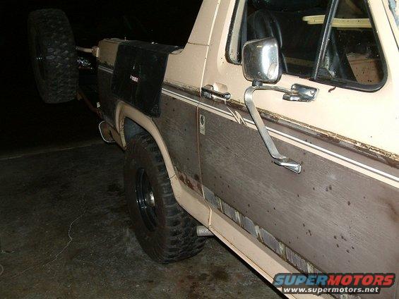 1983 Ford Bronco side view showing spare tire carrier and woodgrain paneling