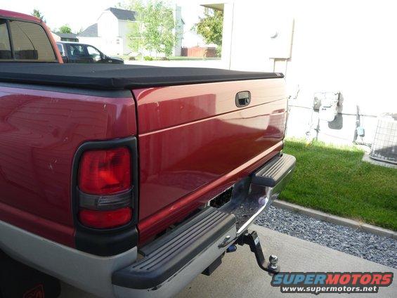 Red 1997 Dodge 2500 rear view with tonneau cover and trailer hitch