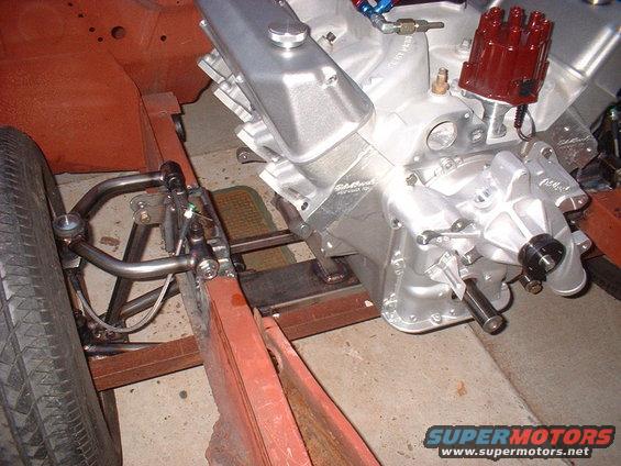 Engine block and front suspension parts of a car, with a tire visible on the left