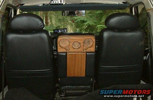Interior view of black seats and wooden console with gauges
