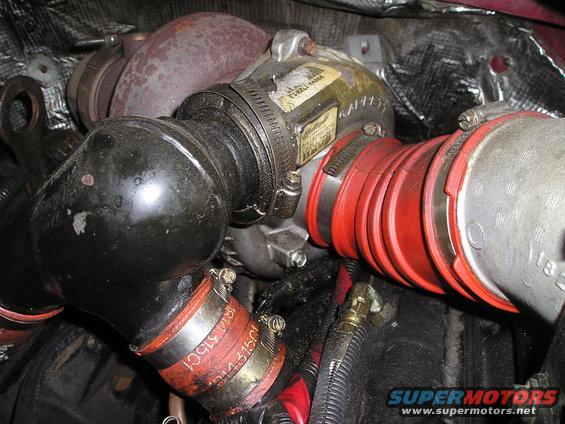 Close-up of turbocharger with red and black intake pipes. Some labels are visible