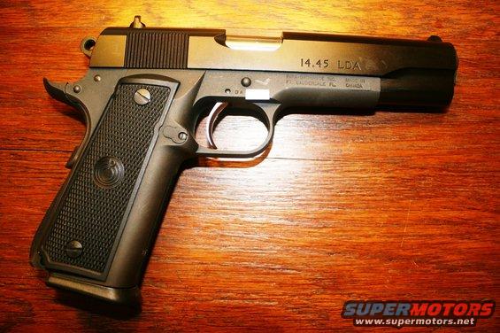 Black 14.45 LDA pistol on wooden surface