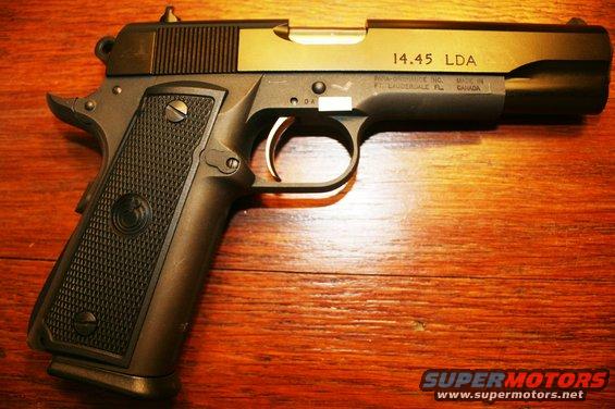 Close-up of a 14.45 LDA handgun on a wooden surface