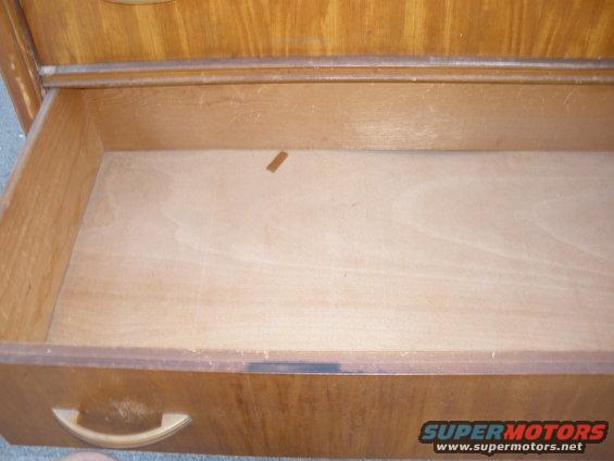 empty wooden drawer with a light-colored handle