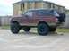 1996 Ford Bronco - This lifted 1996 Ford Bronco features a black soft top and a spare tire mounted on the rear.