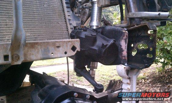 Steering box and radiator assembly, likely from a truck or SUV, with visible rust on the bumper support