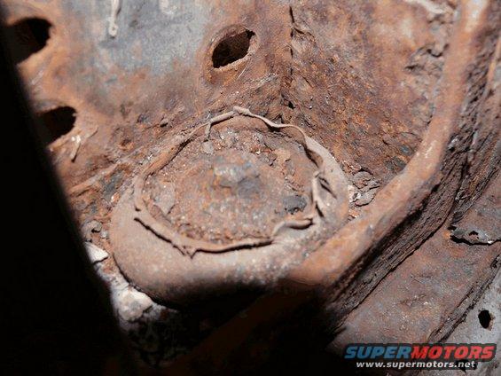 close-up of heavily rusted metal frame with a circular component