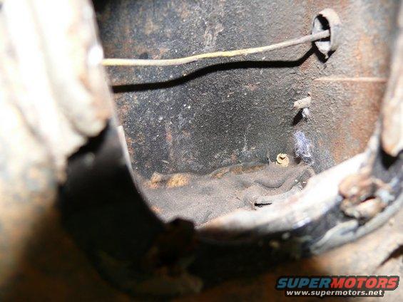 Close-up of rusty metal part with a wire and a screw