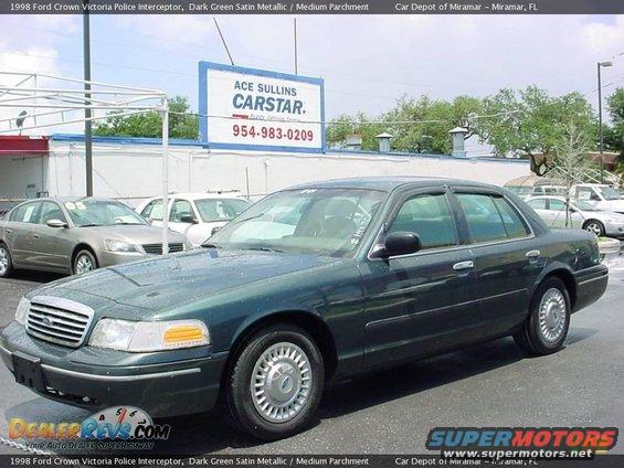 Dark green 1998 Ford Crown Victoria police interceptor, 3/4 front view, parked outdoors