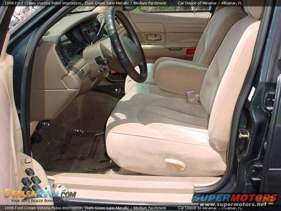 Interior of a 1998 Ford Crown Victoria Police Interceptor, showing tan cloth seats, dashboard, and steering wheel