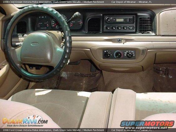 Interior view of a 1998 Ford Crown Victoria Police Interceptor, showing dashboard, steering wheel, and seats