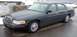 1998 Ford Crown Victoria - A 1998 Ford Crown Victoria sedan is parked on a wet road with snow visible in the background.