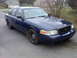 2002 Ford Crown Victoria - Front 3/4 view of a blue 2002 Ford Crown Victoria sedan.