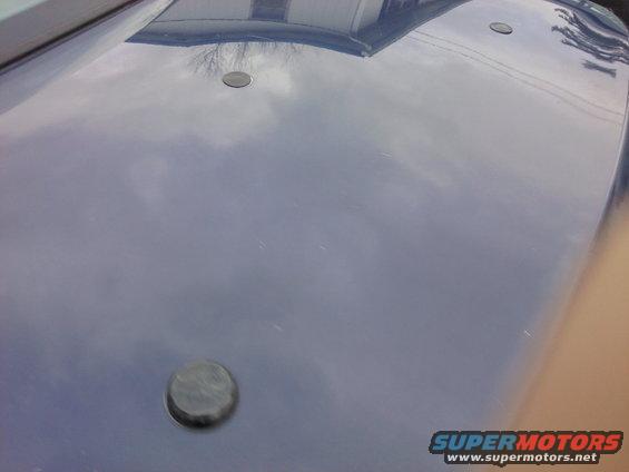 Blue hood with three circular indentations and a Supermotors.net watermark