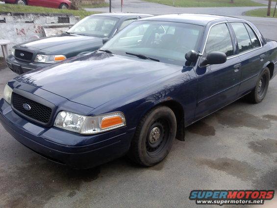 Dark blue 2002 Ford Crown Victoria parked next to a dark green one